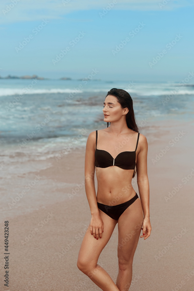 Beautiful woman in swimwear with copy space on the beach. Portrait of pretty girl with slim tanned sexy body in black bikini enjoying life. Summer lifestyle. Vacation Beautiful woman in swimwear with copy space on the beach. Portrait of pretty girl with slim tanned sexy body in black bikini enjoying life. Summer lifestyle. Vacation