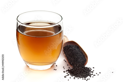 Close-Up of original  organic boiled water (Tea or kada ) of  kalonji (Nigella sativa ) in a transparent glass cup over white background. Original residue in bottom of tea cup photo