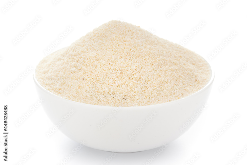 Close-Up of organic fine semolina granules in white ceramic bowl over white background Close-Up of organic fine semolina granules in white ceramic bowl over white background