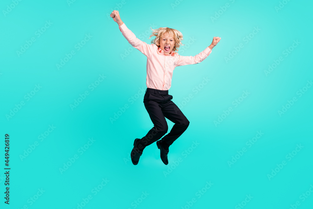 Full length body size view of cheerful crazy boy jumping having fun isolated over bright teal turquoise color background
