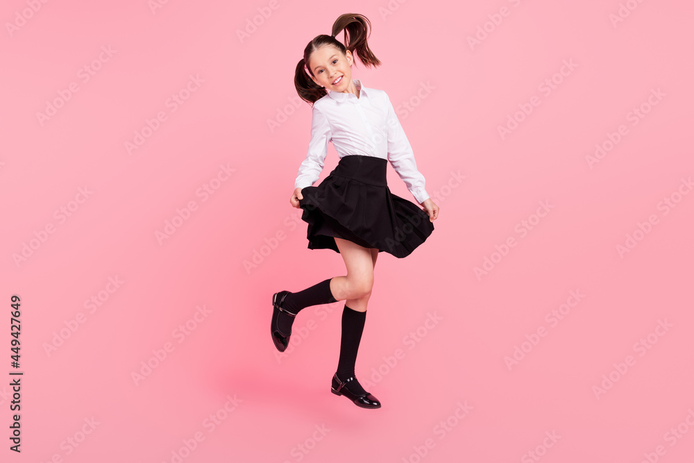 Full size photo of young happy positive happy girl cute smile jump up pupil isolated on pink color background Full size photo of young happy positive happy girl cute smile jump up pupil isolated on pink color background