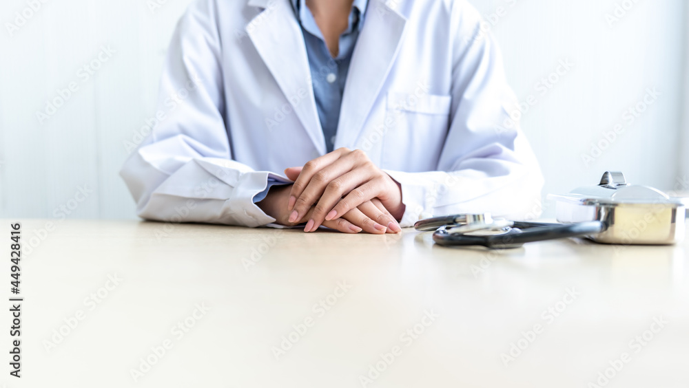 Close up images Hand of woman doctor put on the desk, to people and health care concept.
