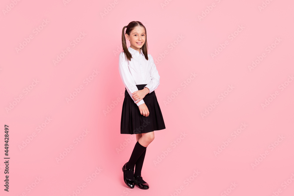 Full body photo of young happy positive small girl wear uniform smile pupil isolated on pastel pink color background Full body photo of young happy positive small girl wear uniform smile pupil isolated on pastel pink color background