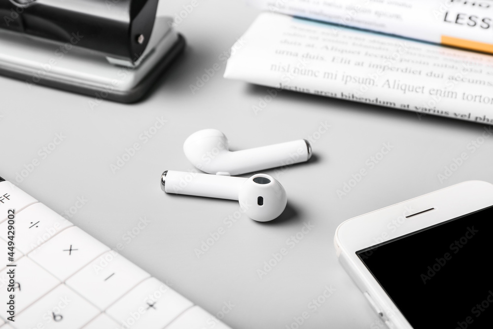 Modern earphones on grey background, closeup Modern earphones on grey background, closeup