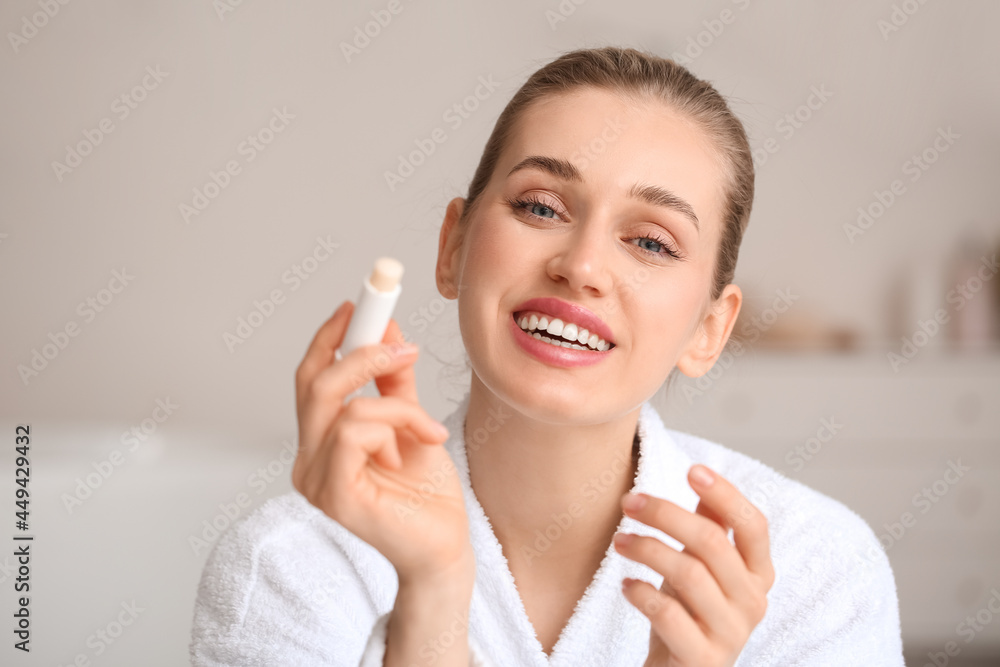 Beautiful young woman with lip balm at home Beautiful young woman with lip balm at home