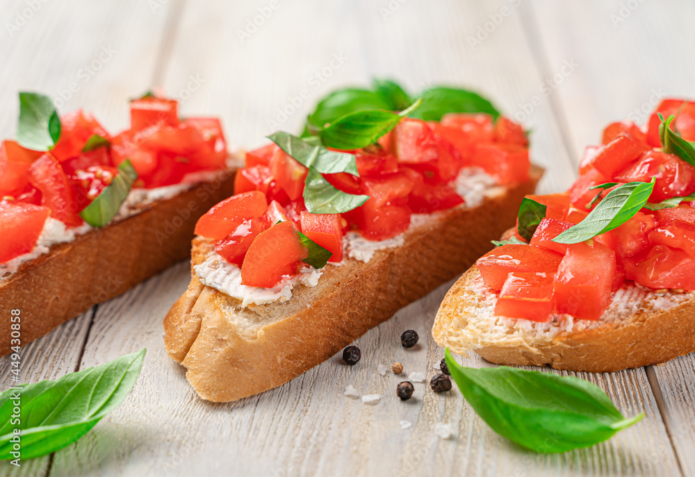 Bruschetta with tomatoes, basil and cheese. A traditional Italian snack.
