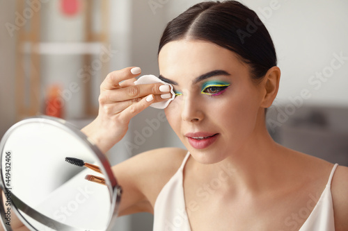 Fotografia Beautiful young woman removing makeup at home