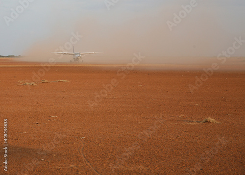 the plane lands on a dirt strip in Africa.