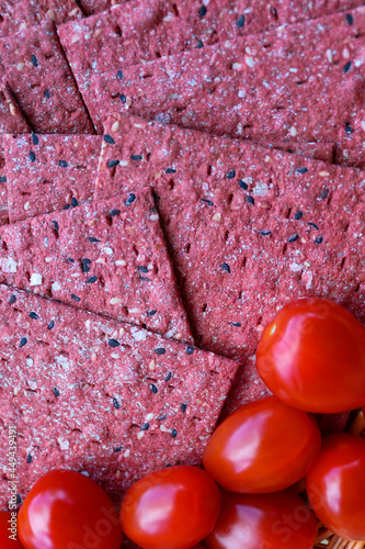 Rootbeet crispbreads and red tomatoes photo