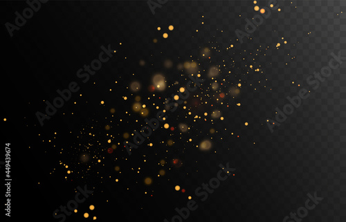 Gold glitter dust on a dark background with lens flares and light effects.