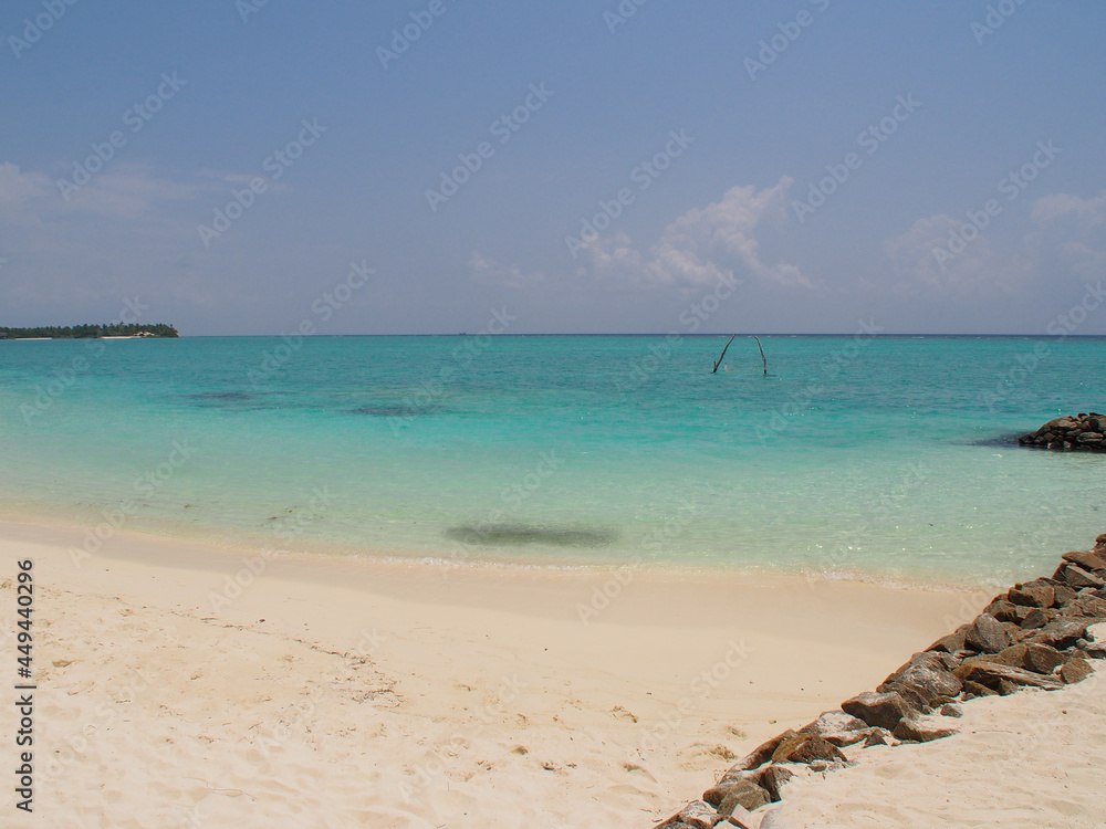 Coast of an island in the Maldives with white sand and blue ocean. Copy space for text.