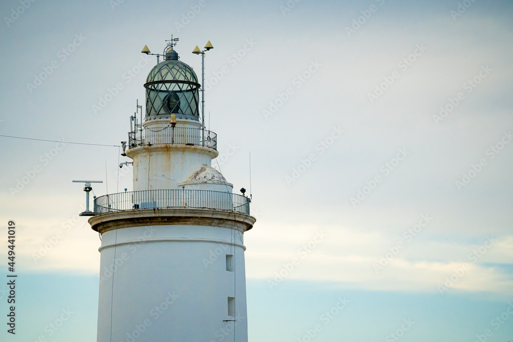 White lighthouse in the center of Malaga in southern Andalusia, Spain, during a sunny summer day at sunset