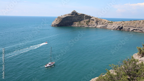 view of the cape on black sea with boat in the bay in crimea 2021