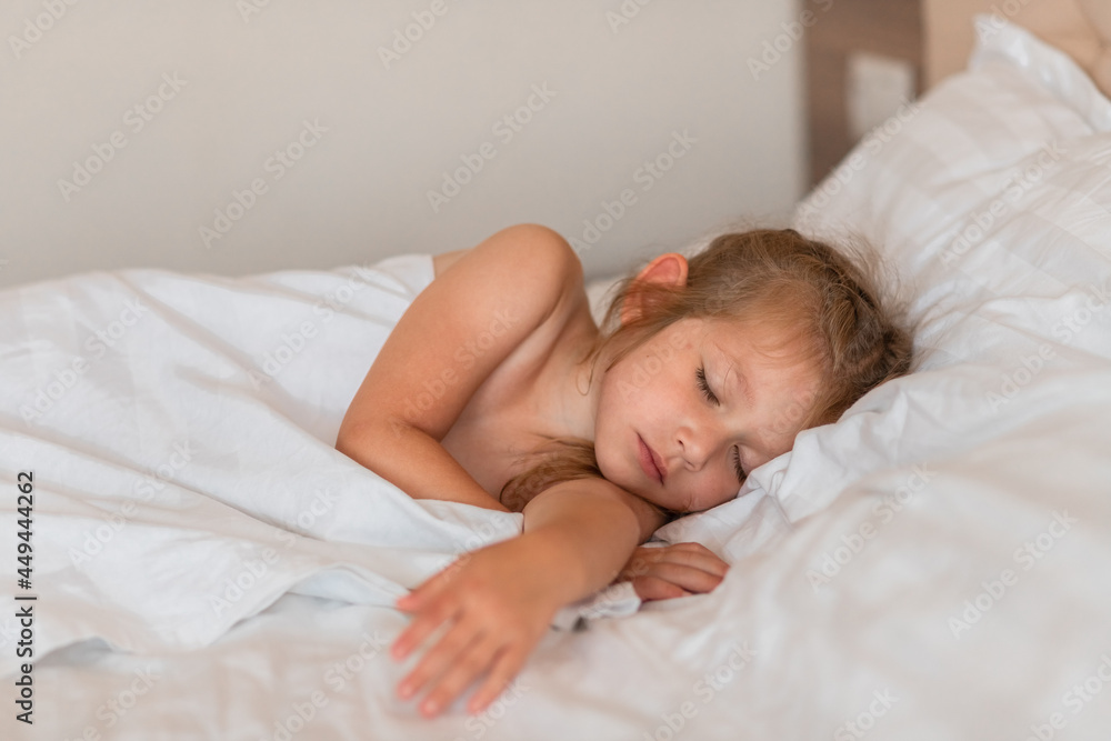 Adorable little girl sleeping in bed with white linens. Place for your text. Healthy baby sleep. Adorable little girl sleeping in bed with white linens. Place for your text. Healthy baby sleep.