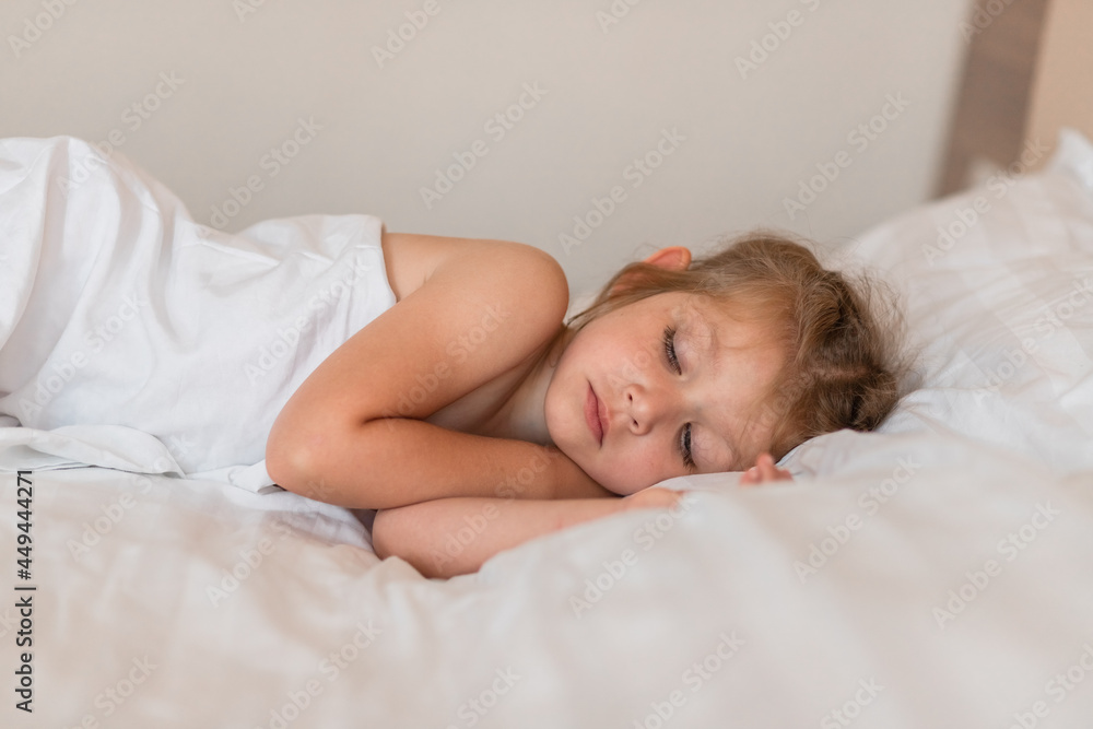 Adorable little girl sleeping in bed with white linens. Place for your text. Healthy baby sleep. Adorable little girl sleeping in bed with white linens. Place for your text. Healthy baby sleep.