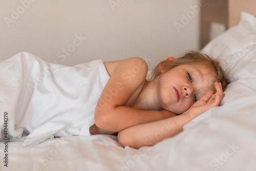 Adorable little girl sleeping in bed with white linens. Place for your text. Healthy baby sleep. © Юлия Немченко