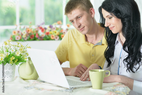 Portrait of happy young couple with laptop