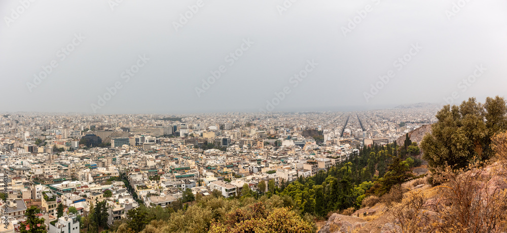 Athens city center streets with white buildings on foggy day. Rooftop panoramic view from Filopappou Hill near Acropolis, Greece