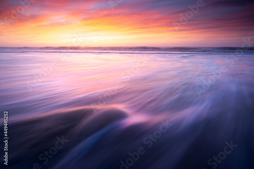 Beautiful sunrise sunset new day on the beach waves motion blur