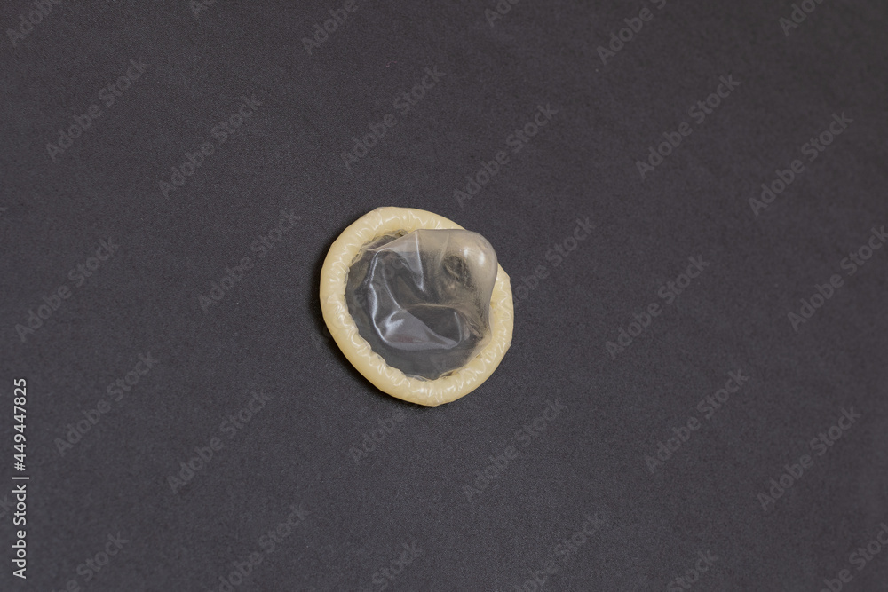 Unpacked Latex Condom On Black Background Unpacked Latex Condom On Black Background