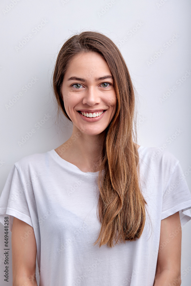 Happy cheerful caucasian woman smiling at camera, having perfect toothy smile, wearing white casual t-shirt, posing, isolated on white studio background. Copy space. People lifestyle concept Happy cheerful caucasian woman smiling at camera, having perfect toothy smile, wearing white casual t-shirt, posing, isolated on white studio background. Copy space. People lifestyle concept