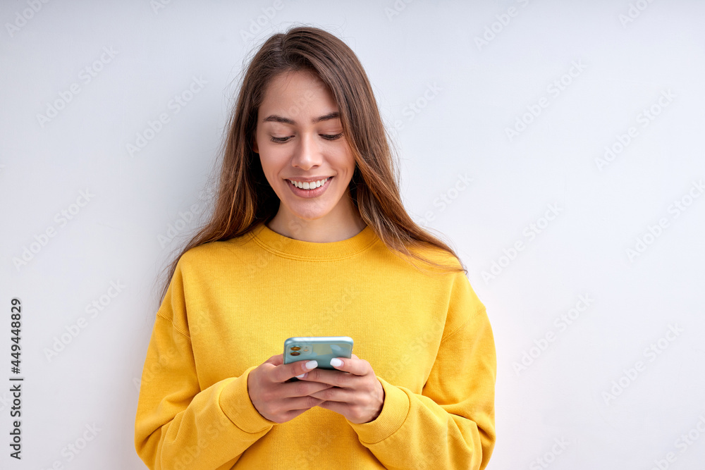 Sweet pretty caucasian woman in casual wear chatting with friend on smartphone isolated on white studio background. Cute Female with long hair smiling, typing message, feel happiness. Copy space Sweet pretty caucasian woman in casual wear chatting with friend on smartphone isolated on white studio background. Cute Female with long hair smiling, typing message, feel happiness. Copy space