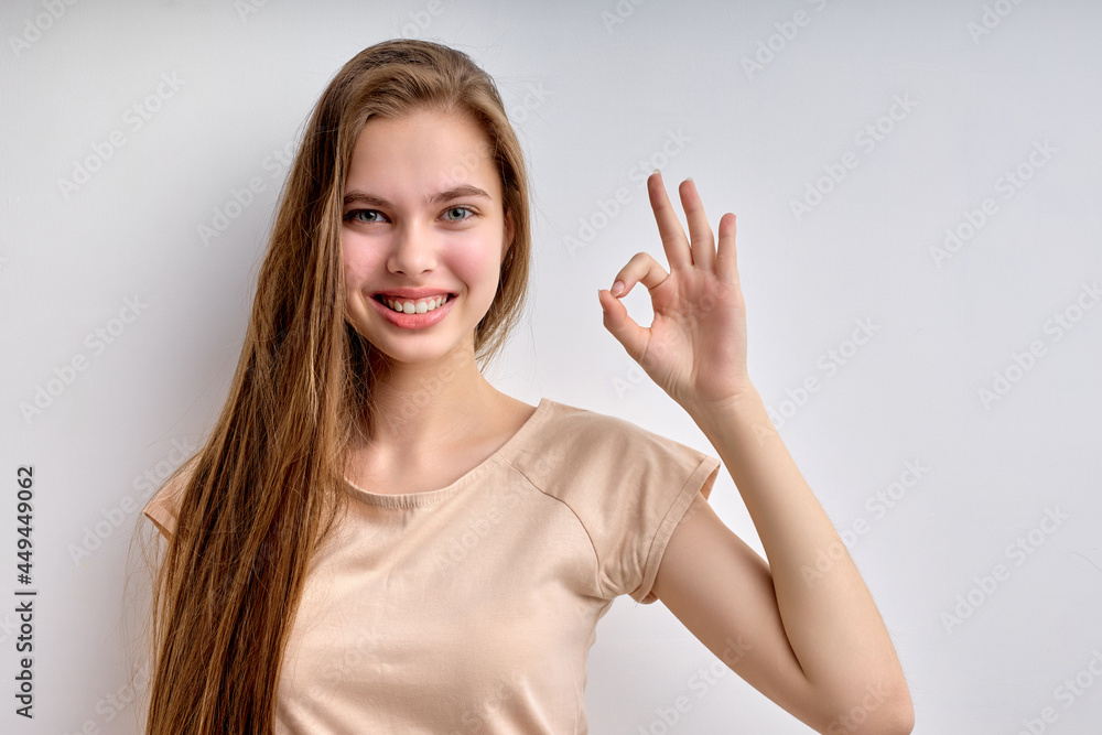 Everything will be OK. good-looking teenage girl with long hair showing ok gesture and smiling, life is good. attractive lady in casual wear look at camera, having nice smile. caucasian girl portrait Everything will be OK. good-looking teenage girl with long hair showing ok gesture and smiling, life is good. attractive lady in casual wear look at camera, having nice smile. caucasian girl portrait