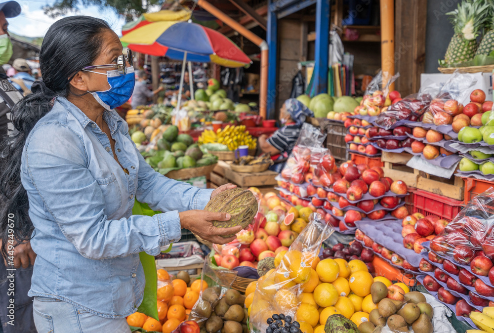 latin woman buying fruit in market. Woman in central american market