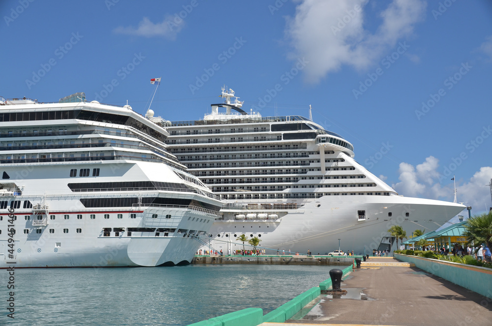 Two cruise ships side by side in port at Nassau showing pier on a sunny summer day