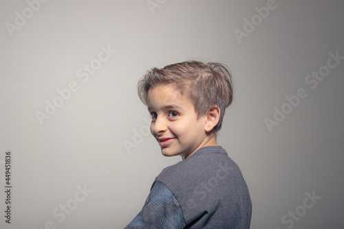 Young smiling and friendly blond child laughing and looking to the side on a white background. Copy space.