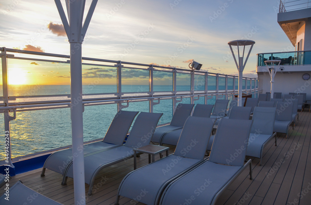 Cruise ship lounger chairs on sun deck at sunset