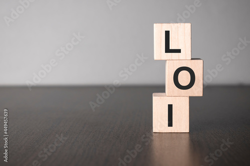 Businesswoman made word loi with wood building blocks.