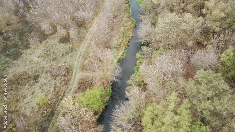 Aerial view of beautiful landscape of river flowing between trees. Bird's eye view of waterway in countryside in autumn weather. Concept of nature background. Aerial view of beautiful landscape of river flowing between trees. Bird's eye view of waterway in countryside in autumn weather. Concept of nature background.