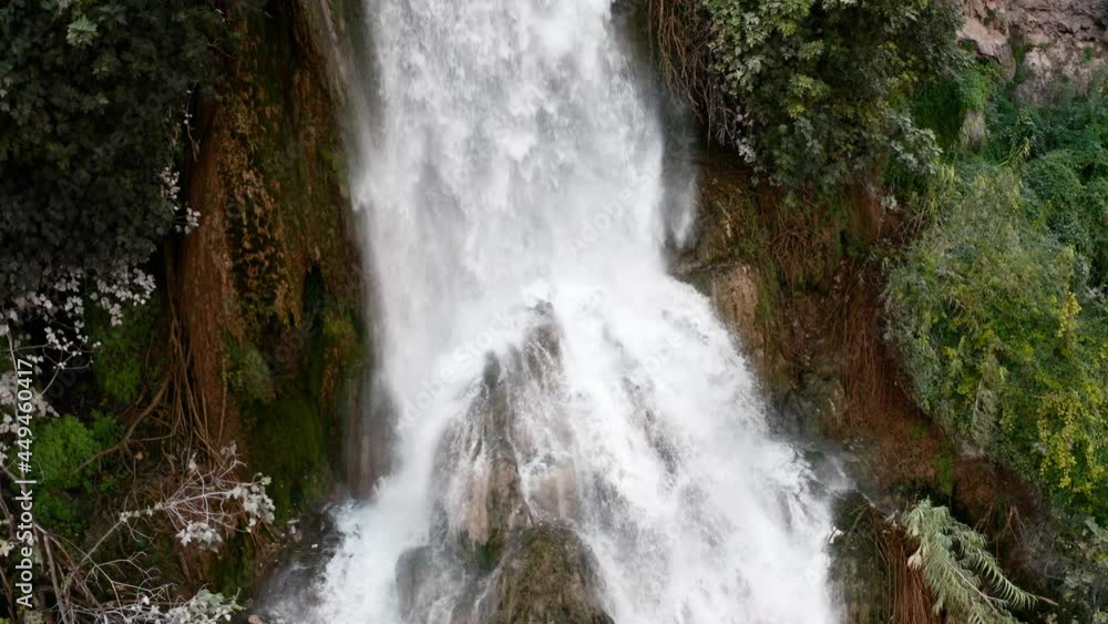 Beautiful mountain Turkish waterfall view from above. Waterfall in the rock with a lot of plants shooting from a drone. The flow of water from the mountain breaks on the ground and stones Beautiful mountain Turkish waterfall view from above. Waterfall in the rock with a lot of plants shooting from a drone. The flow of water from the mountain breaks on the ground and stones