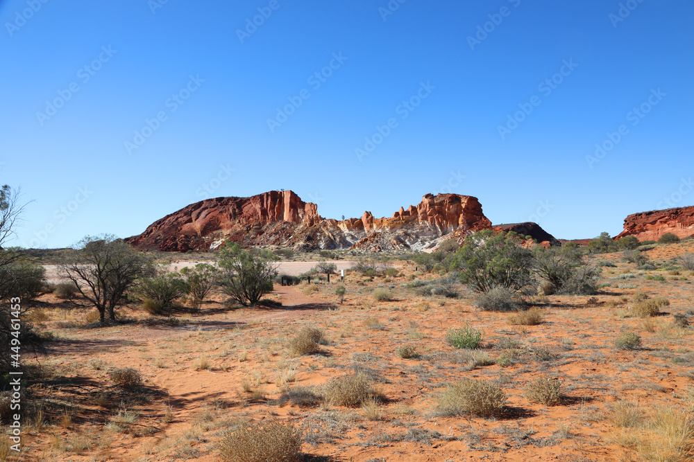 Fototapeta premium Amazing Rainbow Valley in Northern Territory, Australia, just outisde Alice Springs. Beautiful red and orange rock formation with blue sky and orange sands