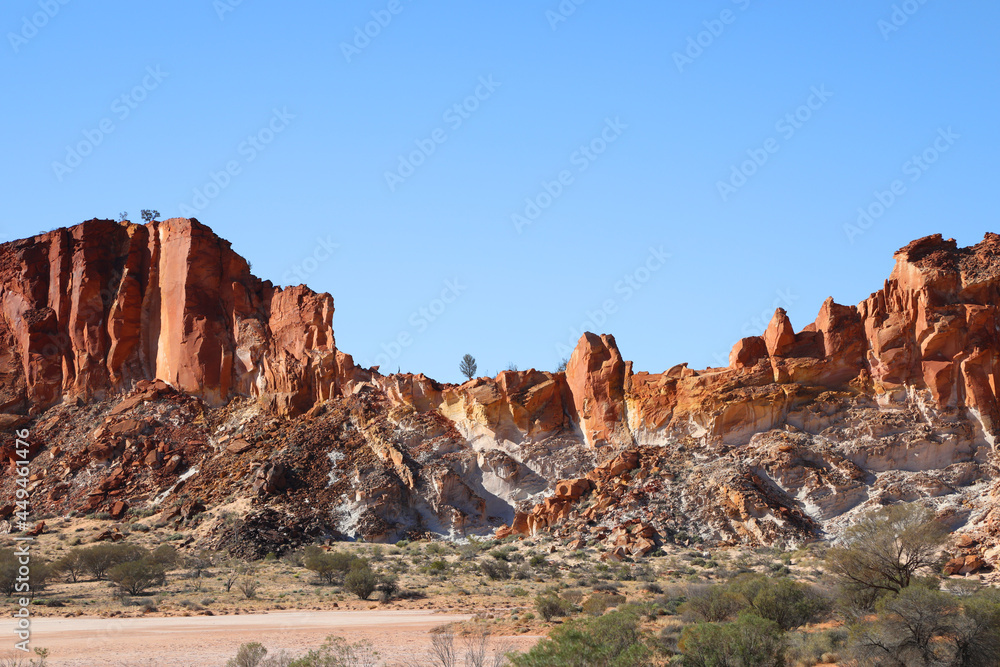 Fototapeta premium Amazing Rainbow Valley in Northern Territory, Australia, just outisde Alice Springs. Beautiful red and orange rock formation with blue sky and orange sands