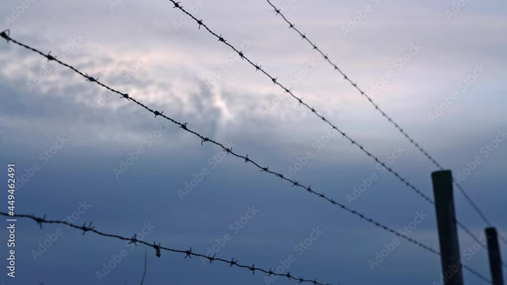 Barbed wire fence under the dark sky Barbed wire fence under the dark sky