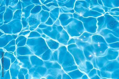 Sun rays are reflected in the blue water of the pool. Close-up