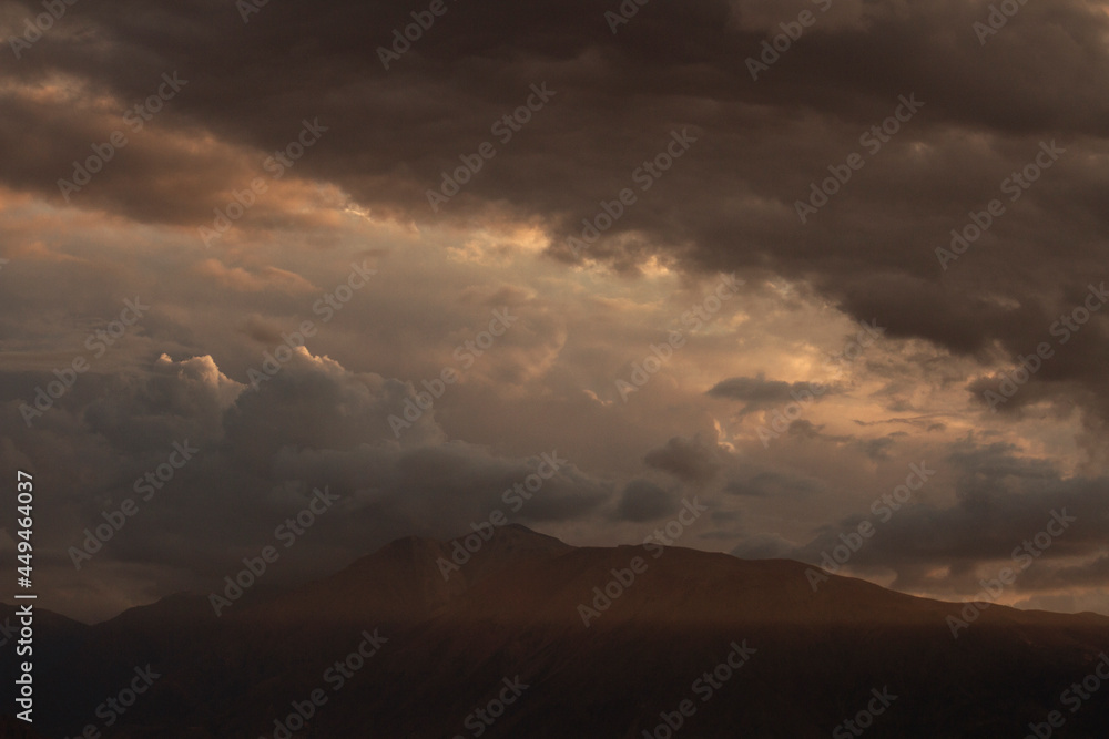 Dramatic sunset in the mountains. View of the Andes mountain range and cloudy sky with beautiful nightfall colors. Dramatic sunset in the mountains. View of the Andes mountain range and cloudy sky with beautiful nightfall colors.