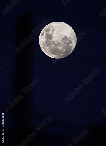 super luna con cielo celeste y encuadre con cables y postes de electricidad photo