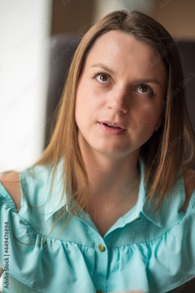 Portrait of a young beautiful brown-haired woman with long hair indoors. Portrait of a young beautiful brown-haired woman with long hair indoors.