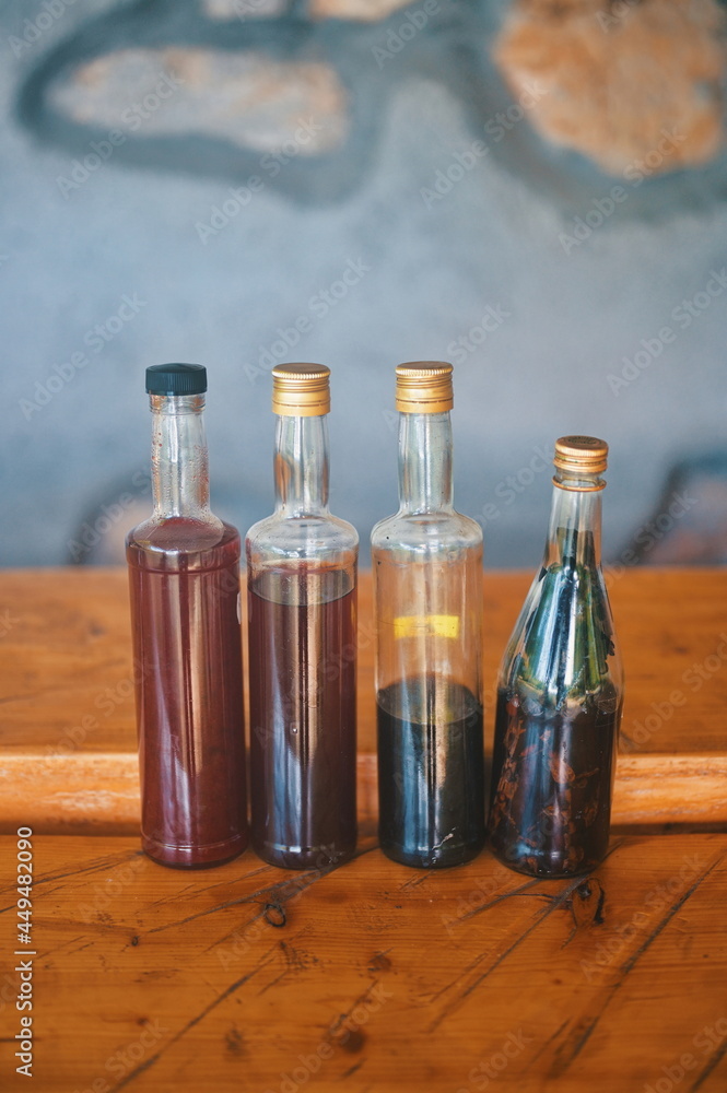 Bottles with homemade brandy on wooden table Bottles with homemade brandy on wooden table