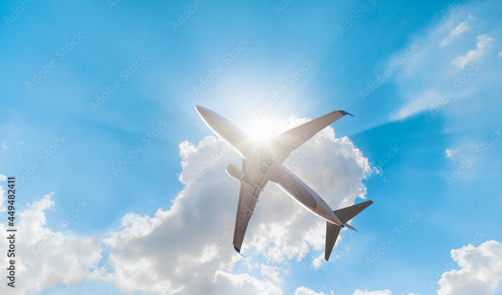 White passenger airplane under the clouds with sun rays - Travel by air transport White passenger airplane under the clouds with sun rays - Travel by air transport