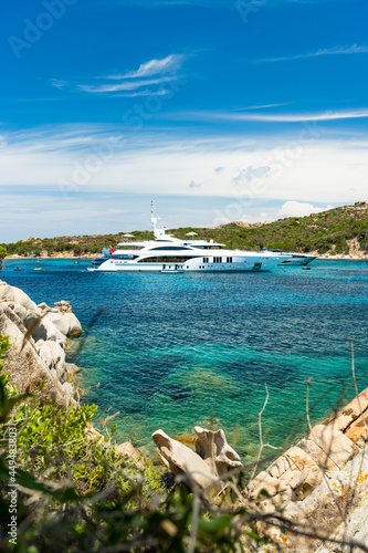 Obraz na płótnie Stunning view of a bay of water with luxury yachts sailing on a turquoise water during a sunny day. La Maddalena archipelago, Sardinia, Italy. w salonie