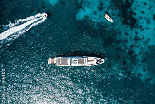 View from above, stunning aerial view of a luxury yacht sailing on a blue water. Costa Smeralda, Sardinia, Italy.
