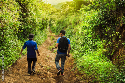 Two men on a path through the countryside, Two young men walking along a path with copy space