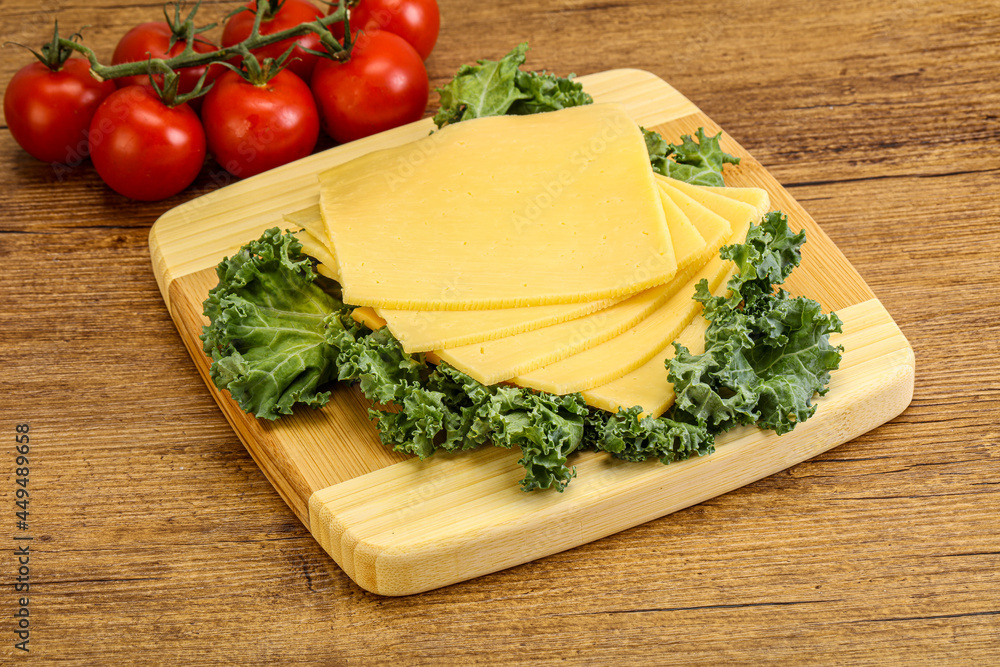 Sliced Gauda cheese over board Sliced Gauda cheese over board