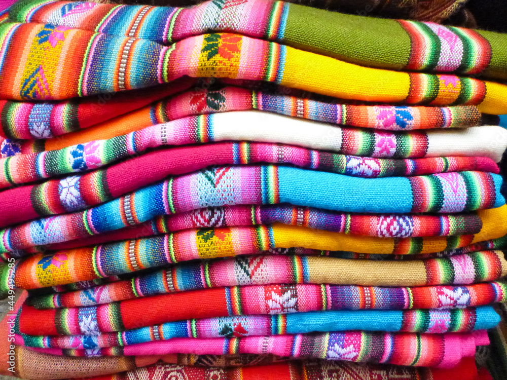 ボリビアの先住民族インディヘナのカラフルなエスニック柄の伝統的織物が積まれた様子