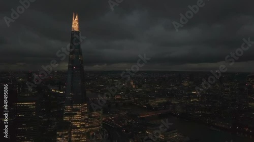 The Shard skyscraper in London city, UK. Aerial drone view of capital cityscape at night, dolly in photo