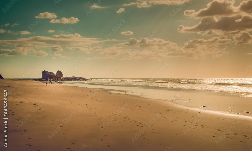 Two surfers walking in the sand on the beach, two surfers walking on the beach with copy space Two surfers walking in the sand on the beach, two surfers walking on the beach with copy space